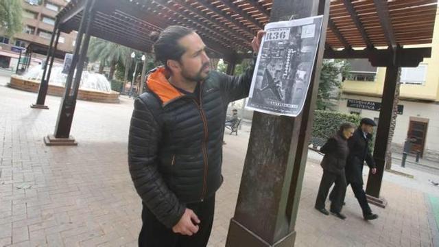 El presidente de la asociación de vecinos Carolines Baixes-Les Palmeretes, Alexandre Morera, con uno de los carteles colocados en la plaza para reivindicar la apertura del refugio.