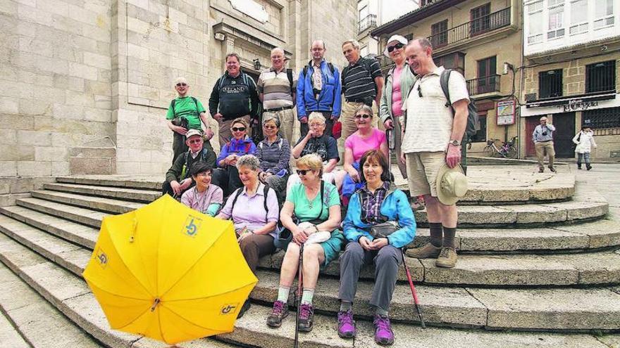 Los peregrinos irlandeses con su guía, Noelia Fdez. (1ª por la izq.), ayer, ante la Colegiata.