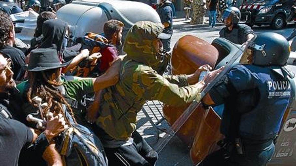 Un piquete de jóvenes antisistema se enfrenta a varios agentes antidisturbios de los Mossos, el miércoles.