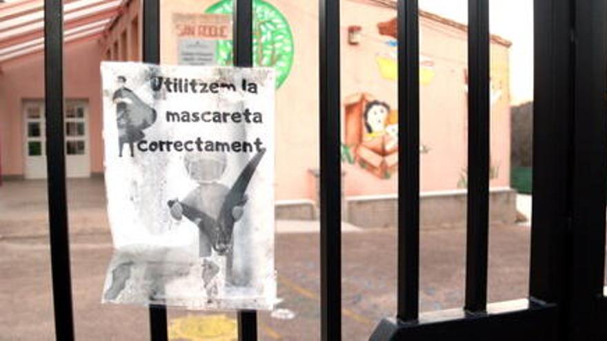 Primer pla d&#039;un cartell sobre l&#039;ús de la mascareta a la reixa tancada de l&#039;entrada de l&#039;escola Sant Roc de Paüls