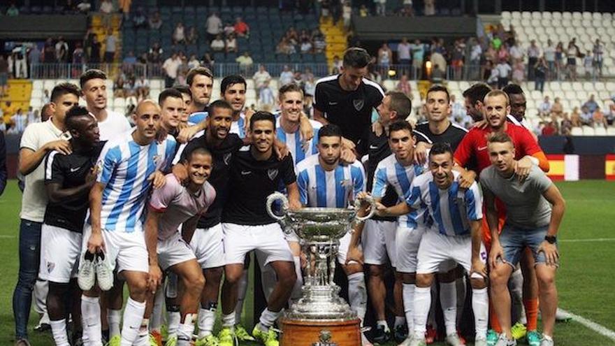 La plantilla del Málaga CF posa con el trofeo que le acredita campeón de «su» torneo veraniego.