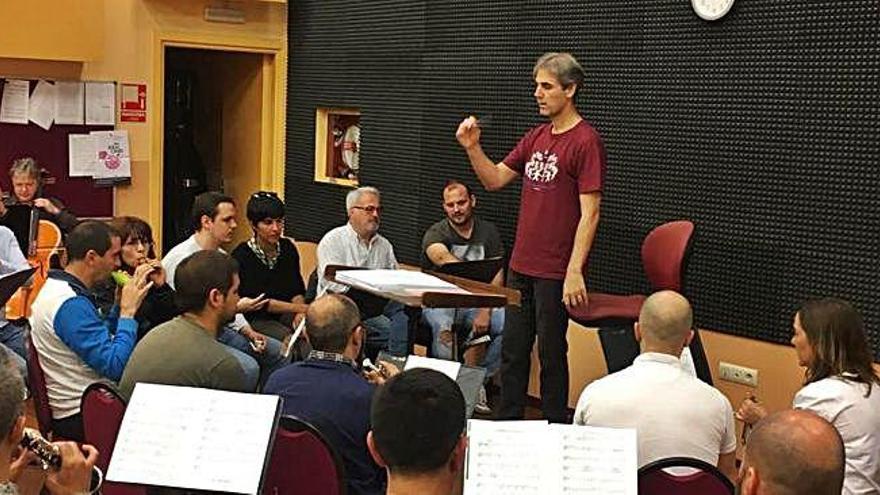 Los cuatro candidatos, sentados a la derecha, reciben instrucciones del director de la banda, de pie.