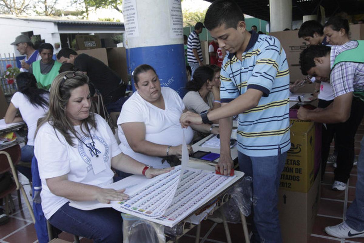 Membres de la junta receptora de vots participen en el recompte, a El Salvador.