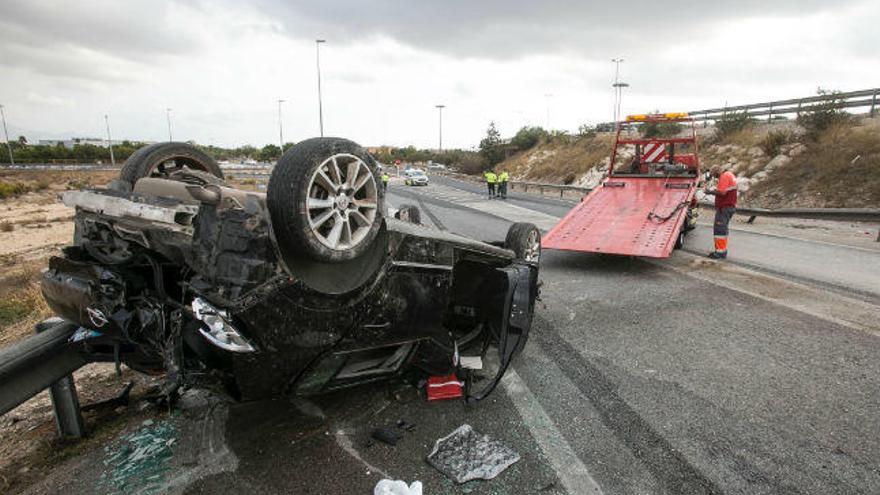 Un coche volcado en un accidente de tráfico junto a la Universidad de Alicante