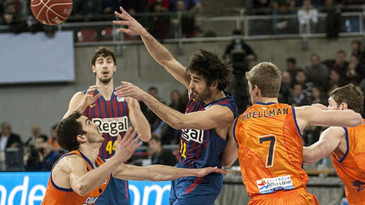 Juan Carlos Navarro pasa el balón ante tres jugadores del Valencia Basket