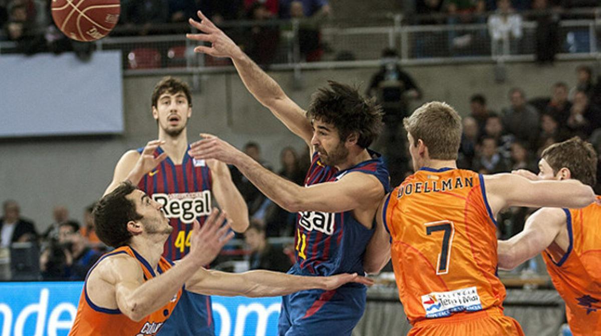 Juan Carlos Navarro passa la pilota davant tres jugadors del València Basket. Juan Carlos Navarro passa la pilota davant tres jugadors del València Basket.