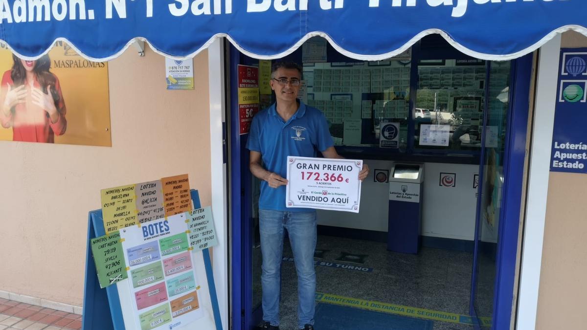 Ildefonso Cardenes Reyes, titular de La Administracion Nº 1 de San Bartolomé de Tirajana, ubicada en San Fernando de Maspalomas, con el cartel del premio.