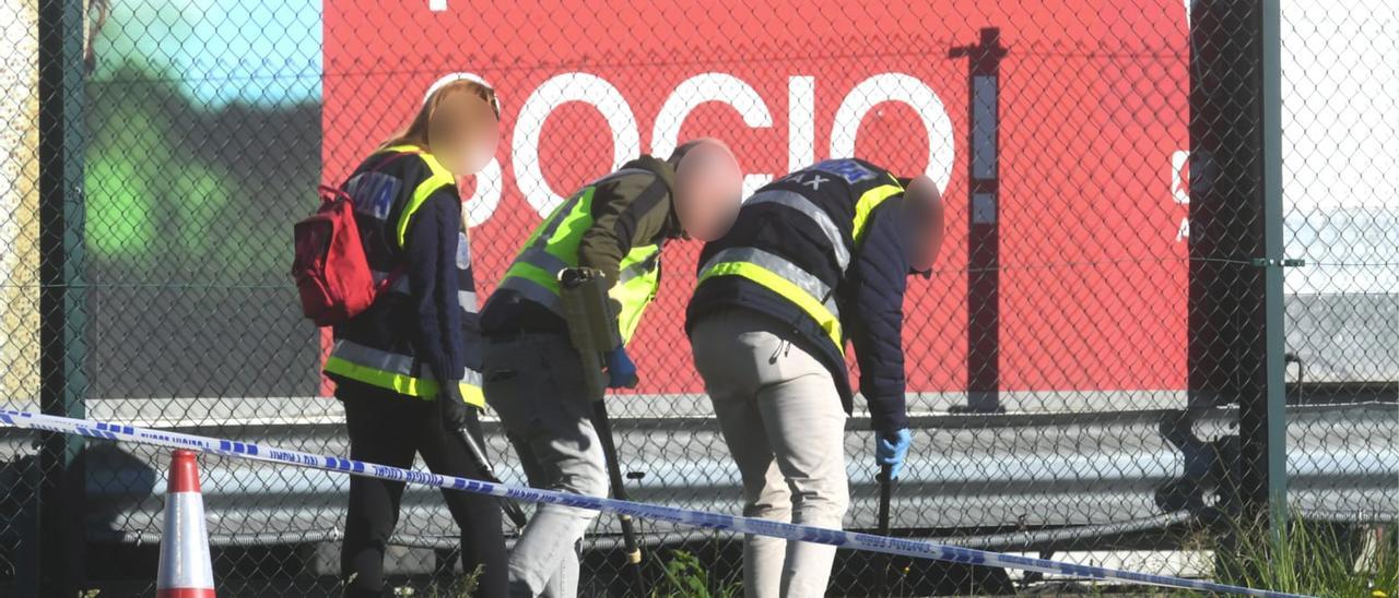 Policías rastrean con un detector de metales en busca de los casquillos de las balas.