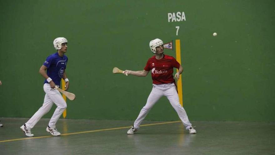 Miguel Laskoiti se dispone a golpear la bola ante la mirada de Carlos Baeza.