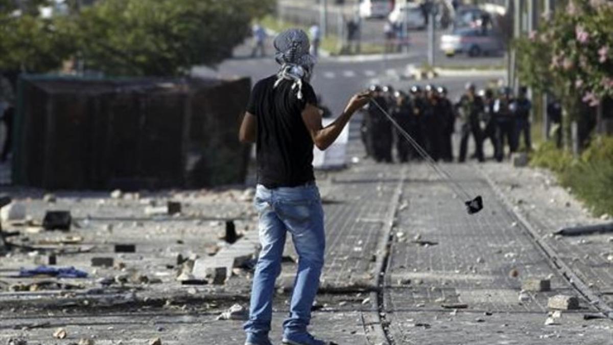 Un joven lanza piedras en una protesta en un suburbio árabe de Jerusalén.