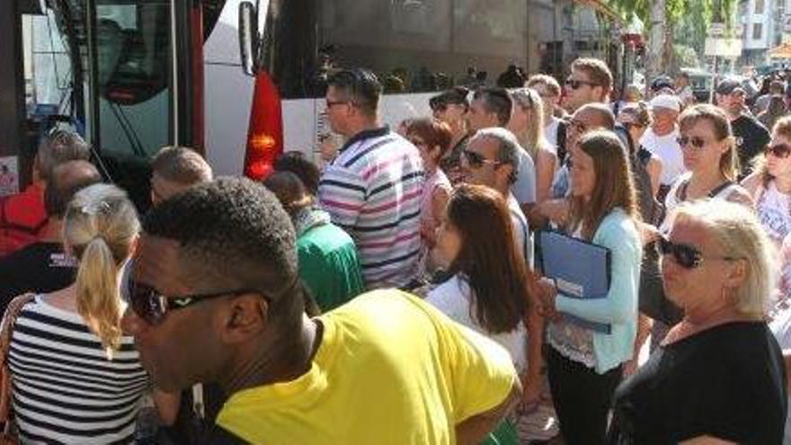 Un grupo de personas accede a un autobús en la parada situada frente a la antigua sede de la Delegación del Gobierno.
