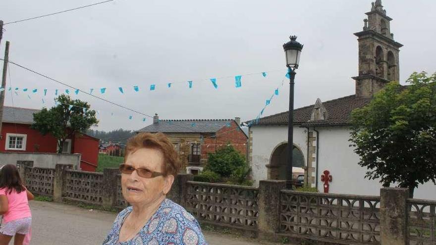 Josefa Martínez, ayer, junto a la iglesia de Abres, aún engalanada con banderas asturianas y gallegas.