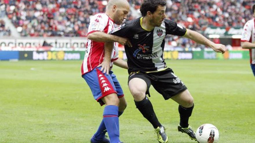 Rubén Suárez controla el balón en el partido de El Molinón, ante la oposición de Lora.