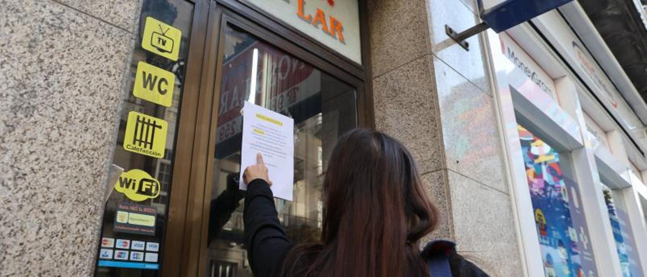 Paula Álvarez, inquilina del Hostal Noso Lar, en Urzáiz, muestra el anuncio de desalojo, ayer.
| // ALBA VILLAR