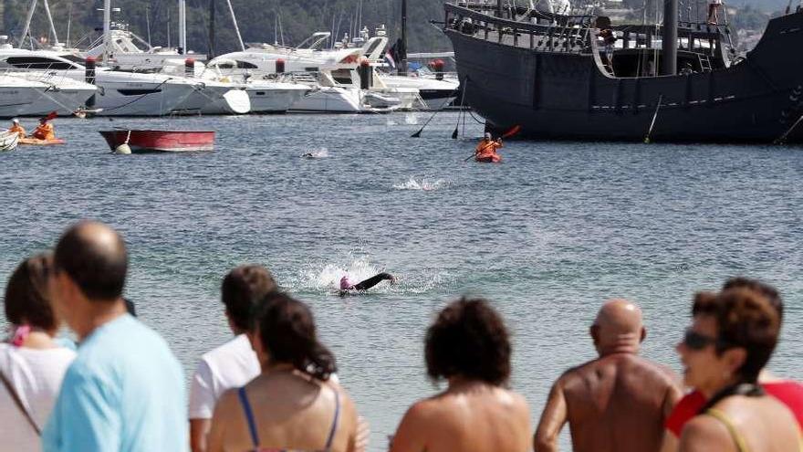 Llegada de los participantes a la playa baionesa de la Ribeira; al lado, los dos ganadores. // J. Lores