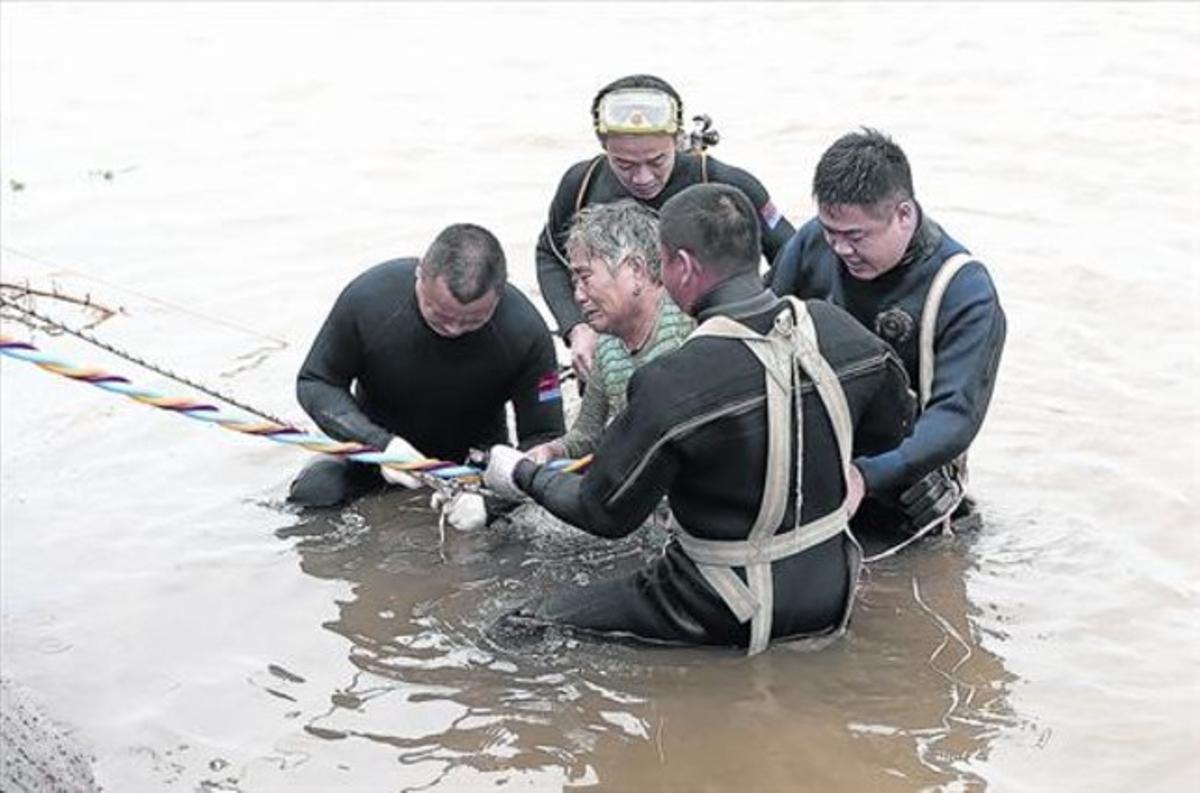 Desolat 8Uns submarinistes acompanyen un jubilat després de ser rescatat del naufragi a la riba del riu Iang-Tsé, a Jianli, ahir. Desolat 8Uns submarinistes acompanyen un jubilat després de ser rescatat del naufragi a la riba del riu Iang-Tsé, a Jianli, ahir.