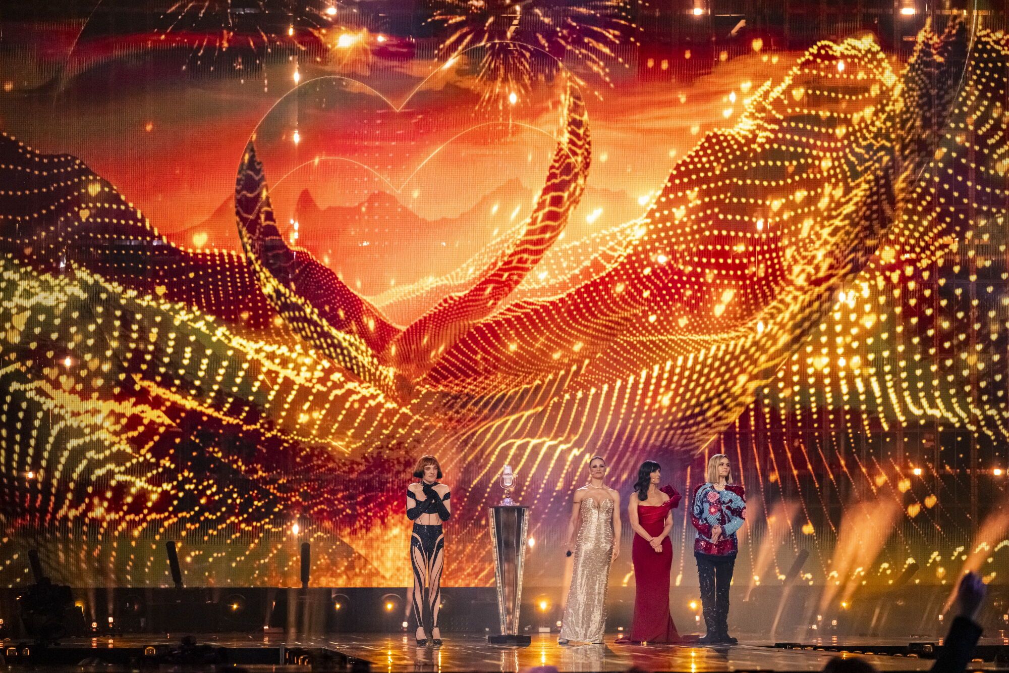 BASEL (Switzerland), 18/05/2025.- (L-R) Nemo of Switzerland, winner of 2024, as well as the hosts Michelle Hunziker, Sandra Studer and Hazel Brugger, look on after the voting at the final at the 69th Eurovision Song Contest in Basel, Switzerland, 17 May 2025. (Suiza, Basilea) EFE/EPA/GEORGIOS KEFALAS