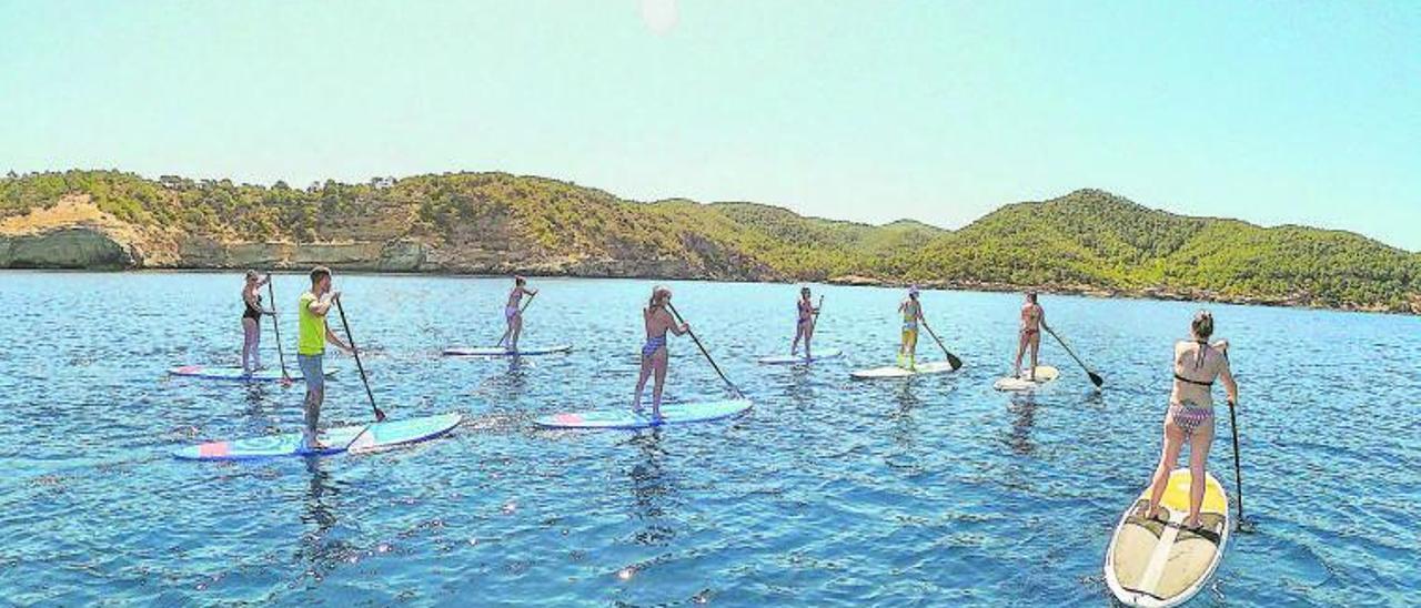 Un grupo de personas durante una excursión guiada en pádel surf.