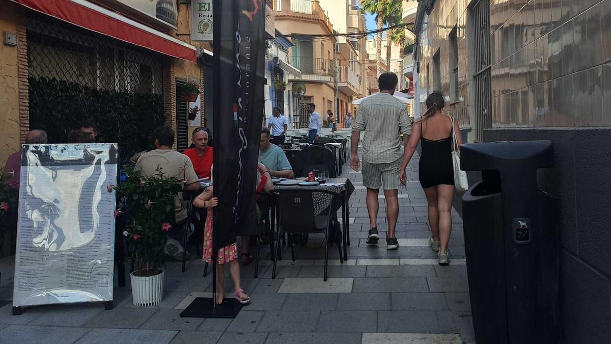 La terraza de un restaurante deja un pasillo de paso a los peatones en el centro de Torrevieja