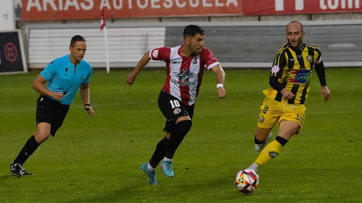 Carlos Ramos conduce el balón en el partido contra Cayón.