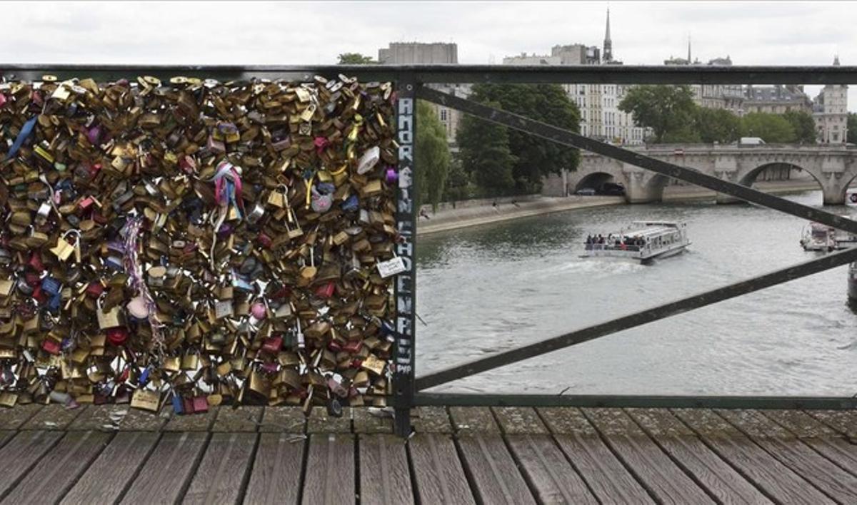 Baranes del pont de les Arts, a París. La de l’esquerra encara manté centenars de candaus, mentre que la de la dreta ja ha sigut buidada per les autoritats de la ciutat.