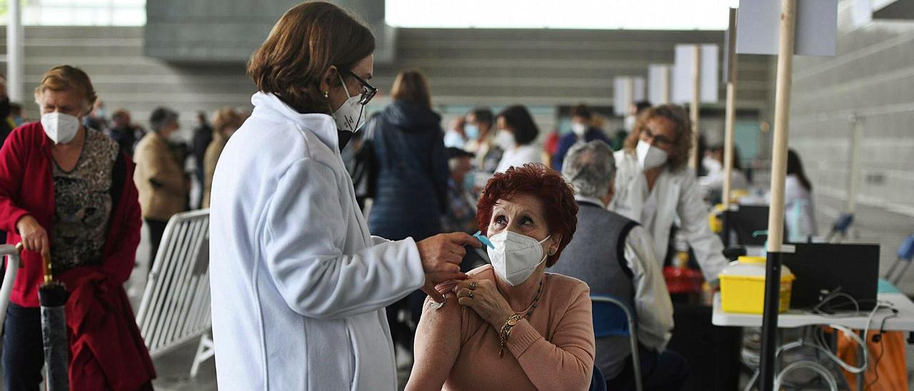 Una mujer recibe la vacuna contra el COVID en la campaña masiva del Recinto Ferial.