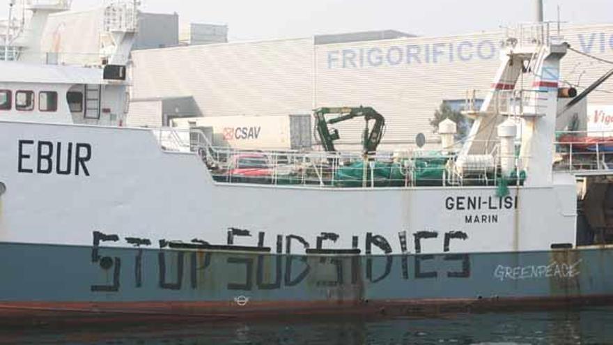 Uno de los arrastreros pintados por activistas de Greenpeace con el mensaje &quot;Stop subsidios&quot;, ayer en el puerto de Vigo.  // Jesús de Arcos