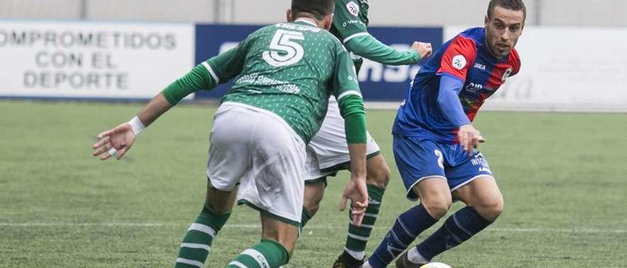 Cristian disputa el balón a Crespo, del Coruxo, en el encuentro celebrado en Ganzábal.