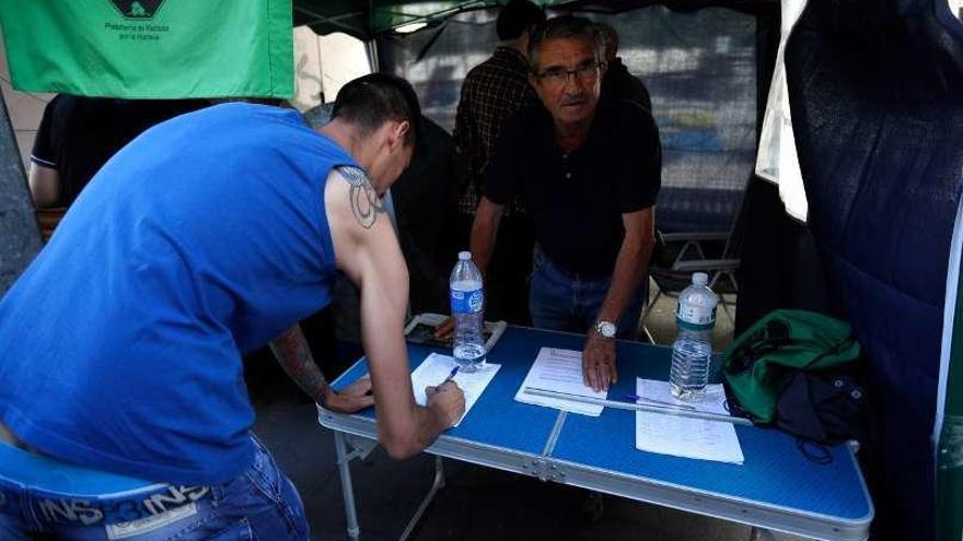 Una persona firma la petición para evitar la subasta.