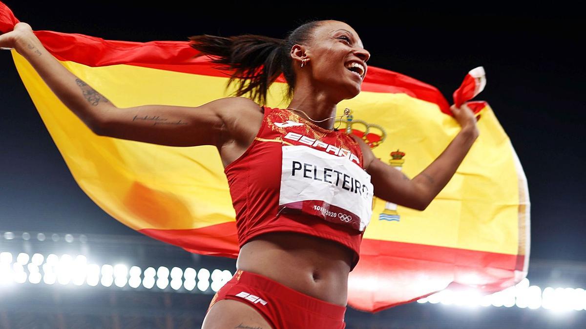 Ana Peleteiro celebra su podio olímpico con la bandera de España tras la prueba de triple salto.