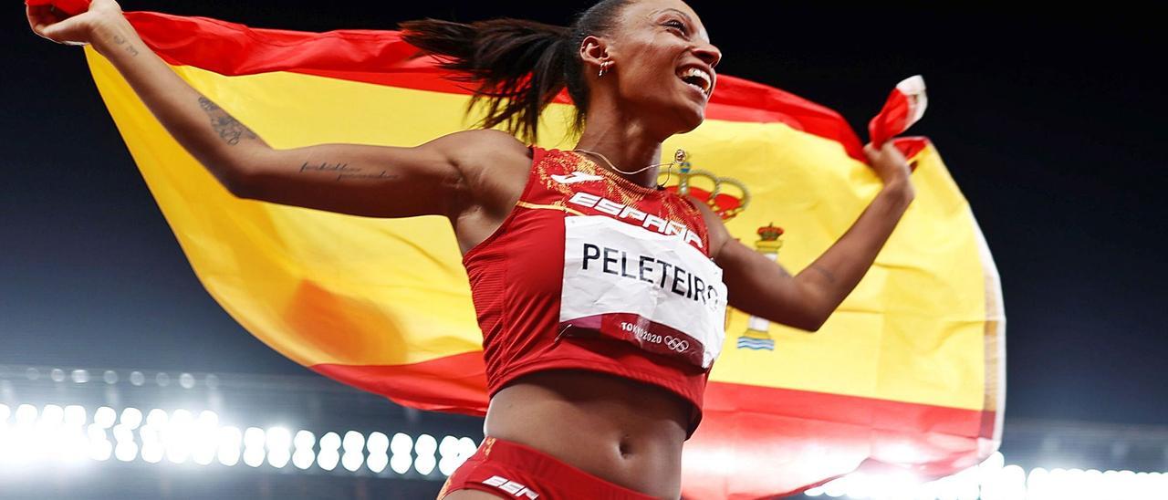 Ana Peleteiro celebra su podio olímpico con la bandera de España tras la prueba de triple salto. | EFE