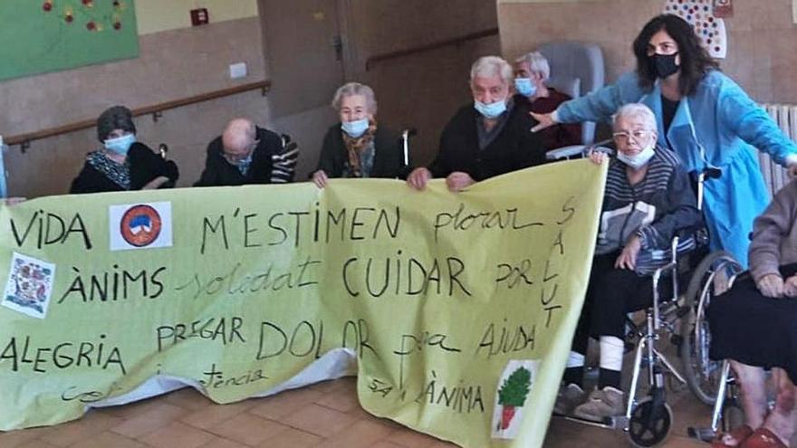 Usuaris de la residència amb una pancarta feta durant les sessions de treball del dol