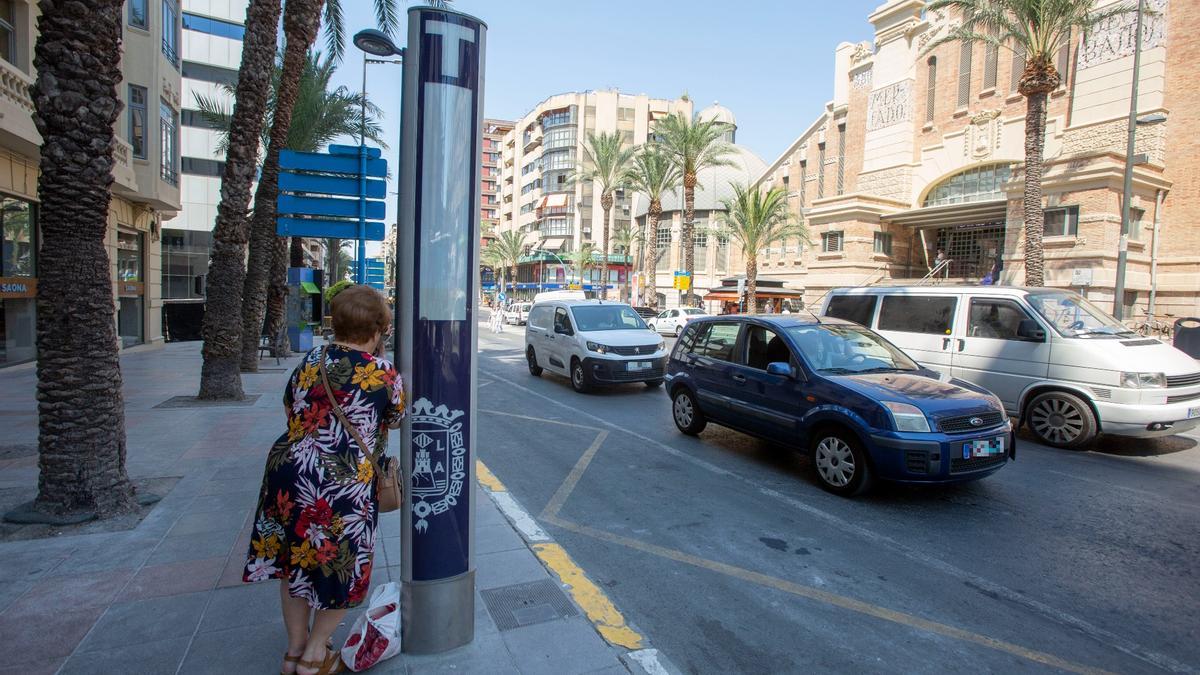 Una mujer espera en la parada de taxis del Mercado Central en Alicante