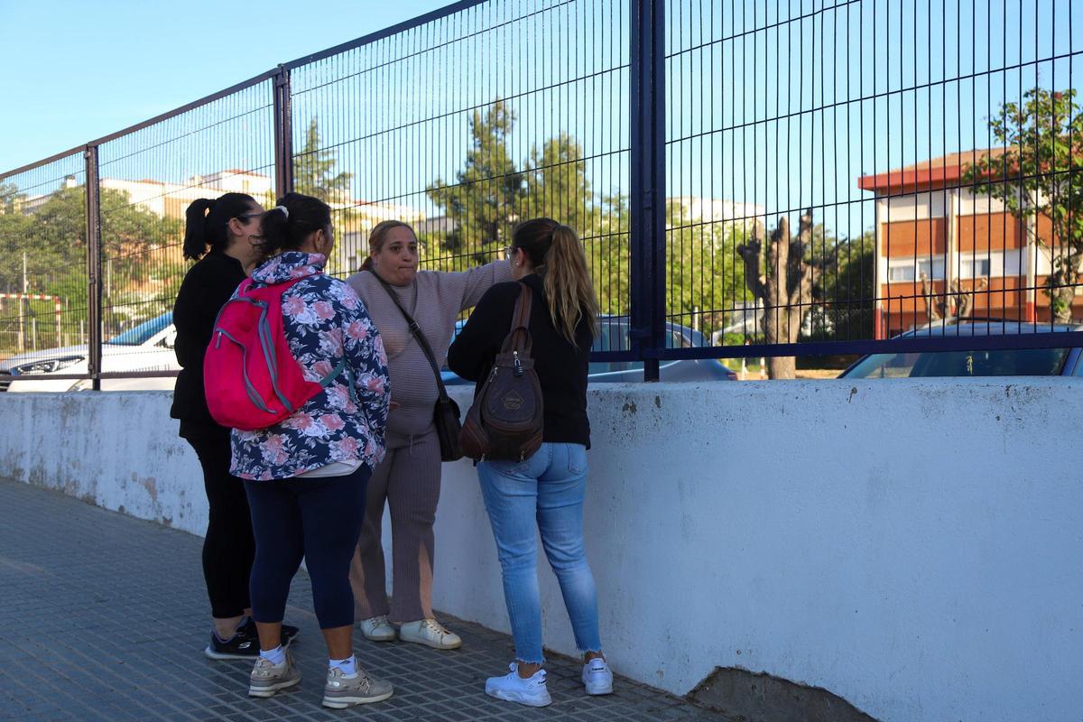 Familias de alumnos, junto a la valla del colegio tras dejar ayer a sus hijos en el interior.