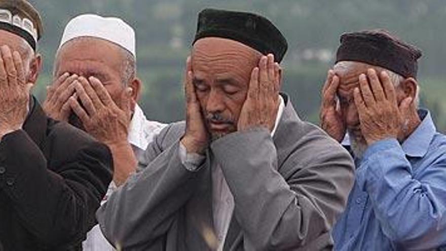 Un grupo de hombres llora la pérdida de sus seres queridos durante su entierro en la localidad de Jelal-Abad, Kirguizistán