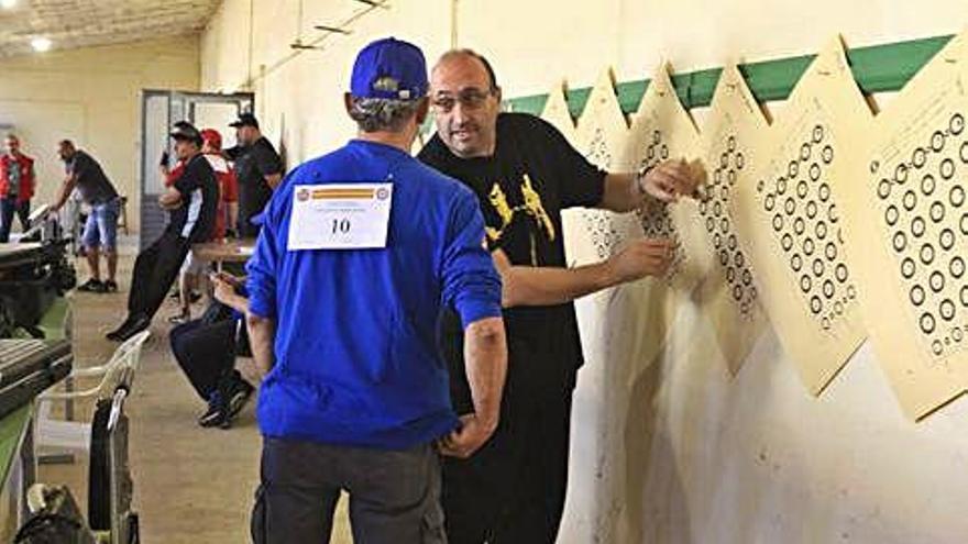 Dos participantes examinan las dianas con los disparos.