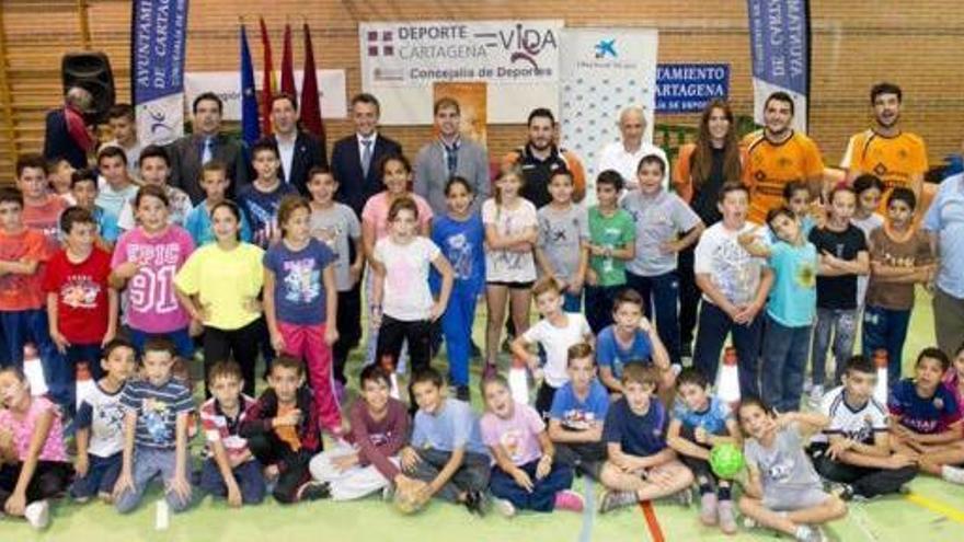 En la imagen los dirigentes políticos y de La Caixa, monitores y niños antes del entrenamiento.