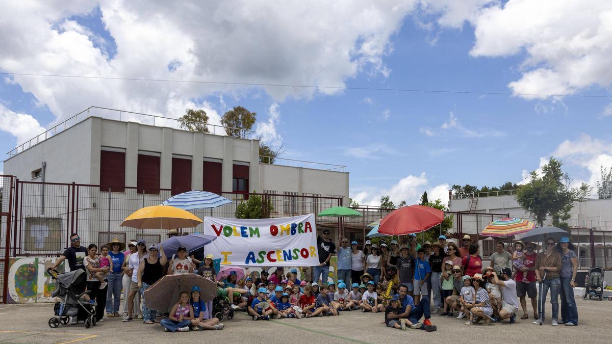 Protesta de padres y alumnos del CEIP Establiments con sombrillas para reclamar sombra en el patio el año pasado.