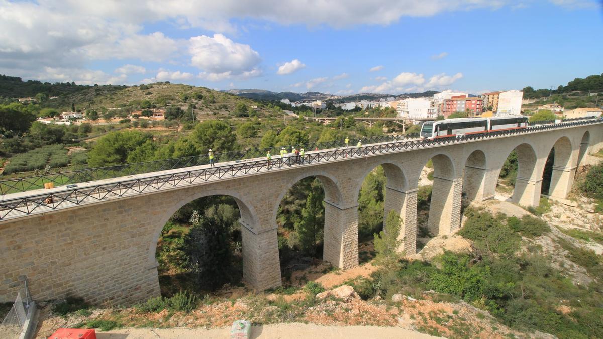 El tren pasa por el puente histórico de Gata de Gorgos durante un trayecto en pruebas