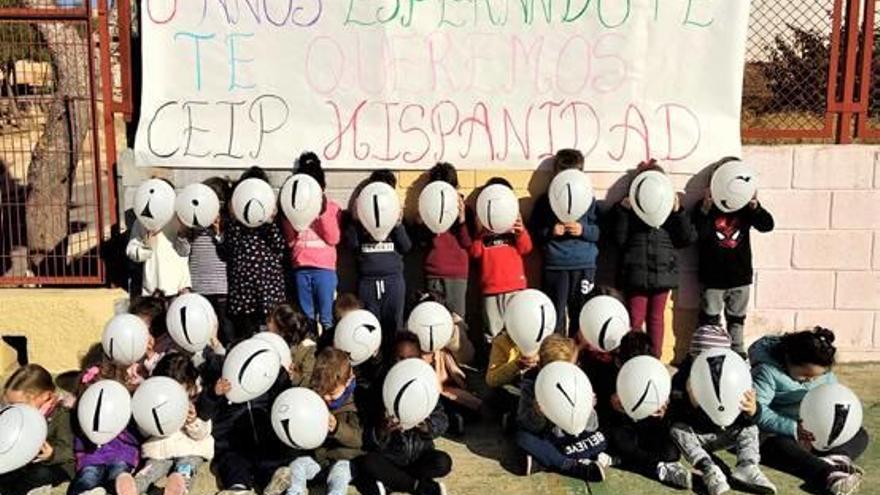 Un grupo de madres y padres ayer portando la pancarta.