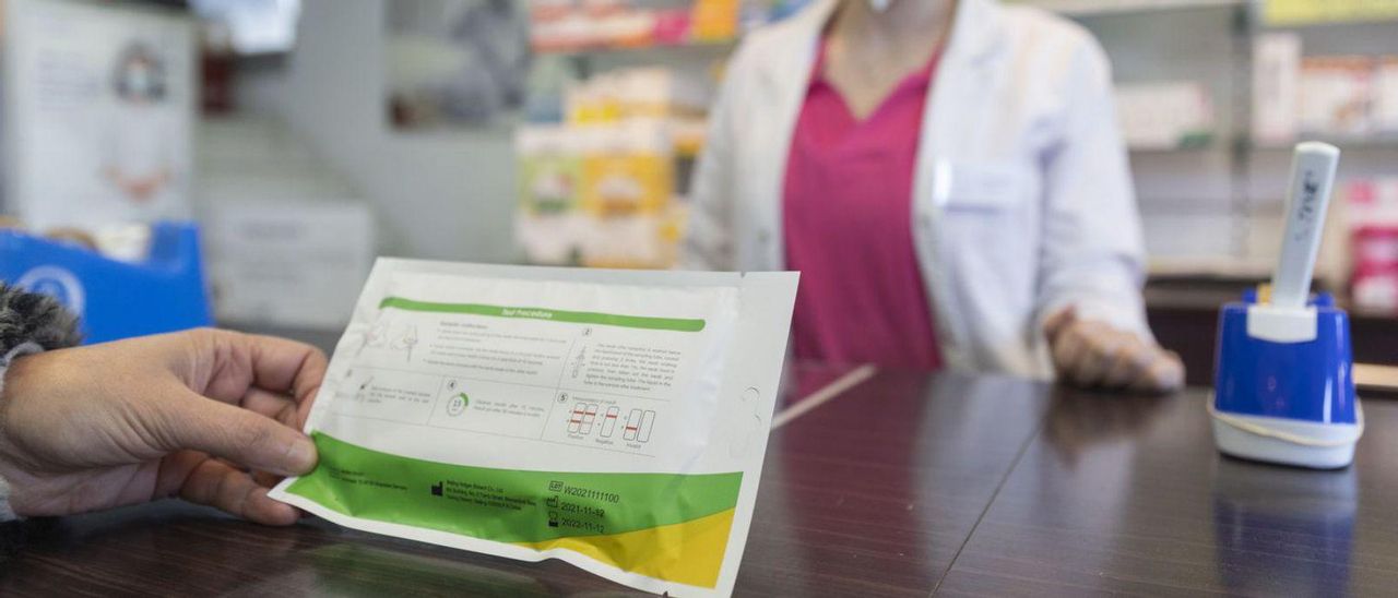 Una mujer compra un test COVID de antígenos en una farmacia.