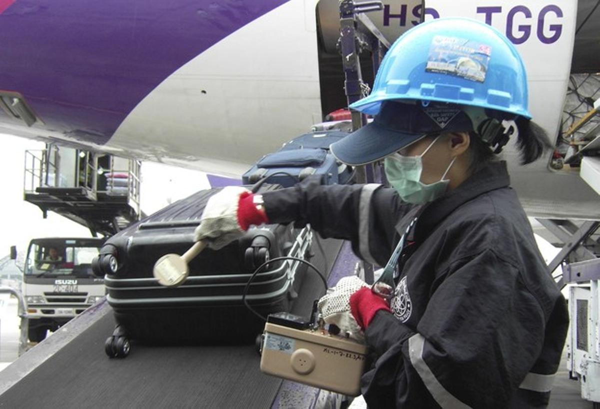 Un oficial d’Àtoms per a la Pau escaneja les maletes d’un vol procedent del Japó per detectar una possible contaminació radioactiva, a l’aeroport Suvarnabhumi de Bangkok.