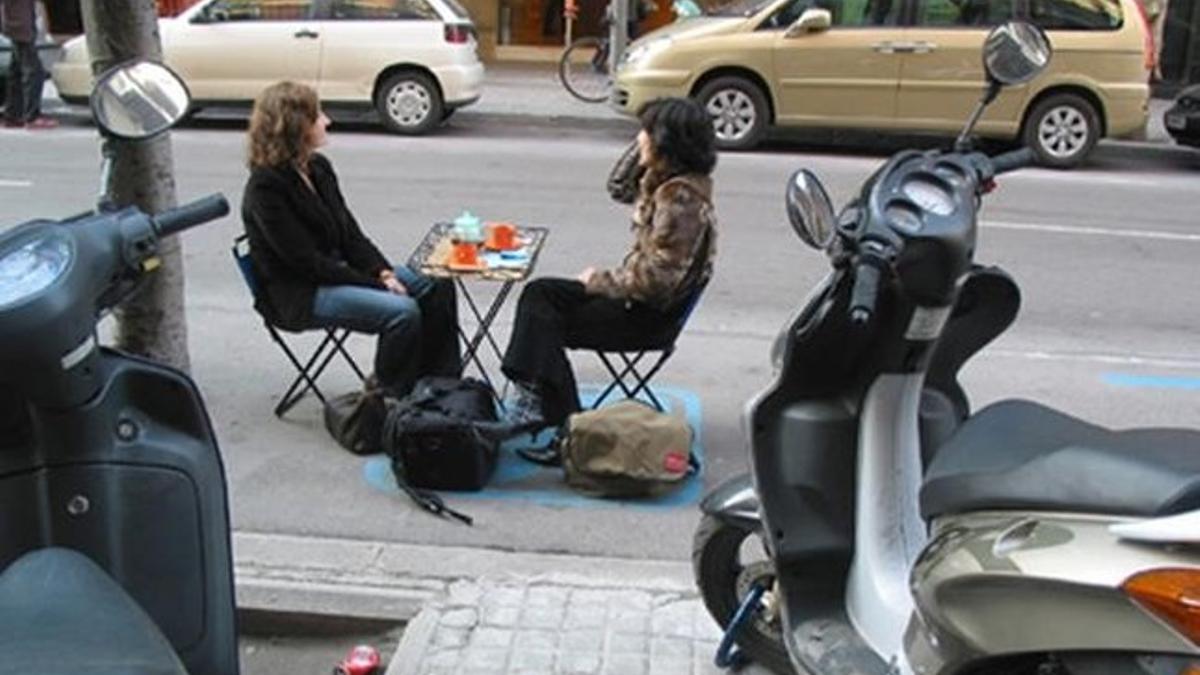 Dos jóvenes toman un café en una zona azul 'ocupada', en el 2003. Era un experimento dentro de la iniciativa 'Terapias urbanas'.