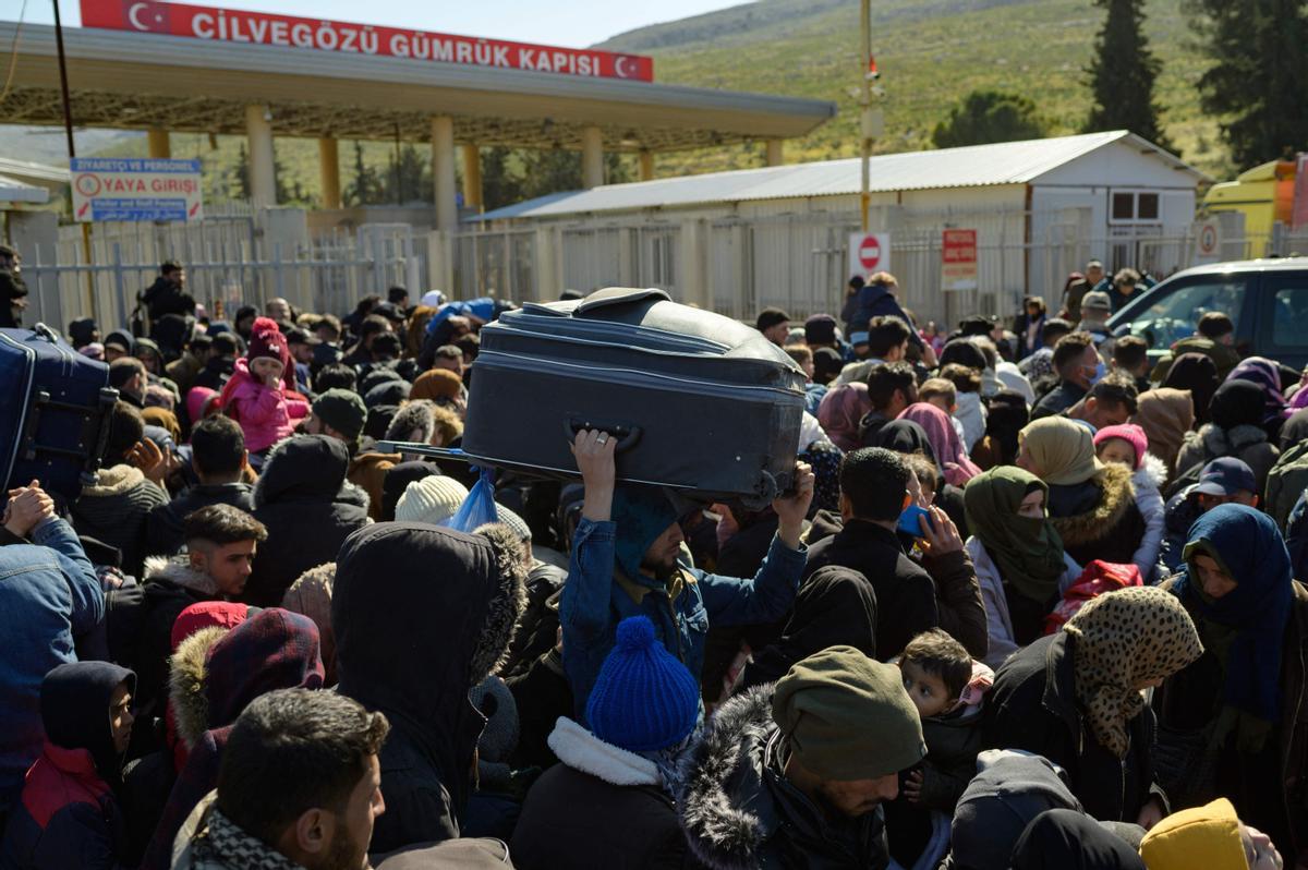 Los residentes sirios de la ciudad de Hatay esperan para cruzar la frontera entre Turquía y Siria después de que se vieron afectados por el terremoto de magnitud 7,8 que asoló la región hace casi dos semanas, en la puerta fronteriza de Cilvegozu