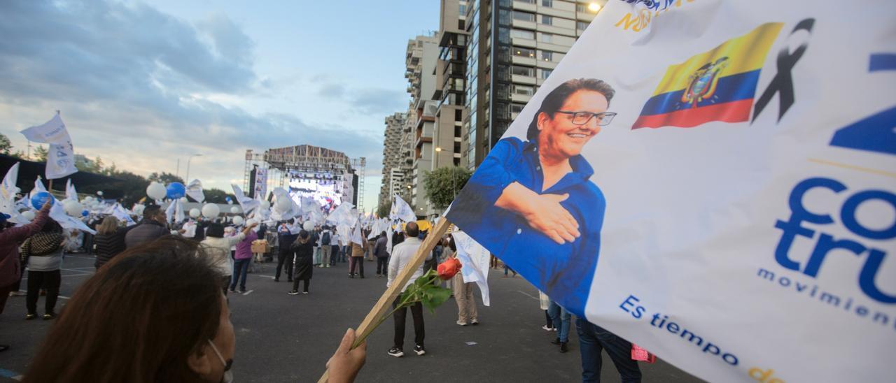 Una simpatizante del candidato ecuatoriano asesinado Fernando Villavicencio ondea una bandera con su rostro, este jueves en Quito.