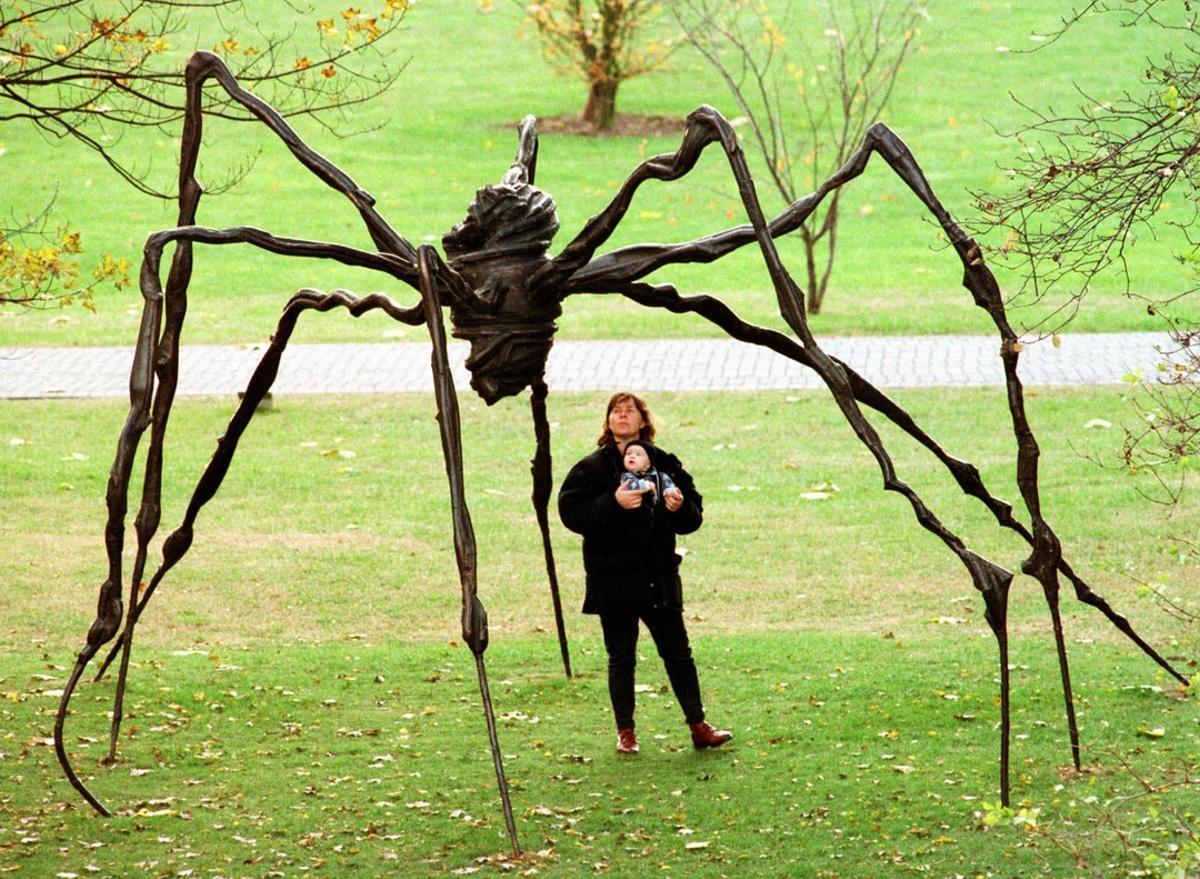 A mother with her baby examines the sculpture Spider by French artist Louise Bourgois at Cologne’s Sculpture Park Exhibition Monday November 10, 1997. The 3.5 meters x 5 meters bronze sculpture is one of 30 sculptures of international artists shown in this exhibition. (AP Photo/Roland Weihrauch)