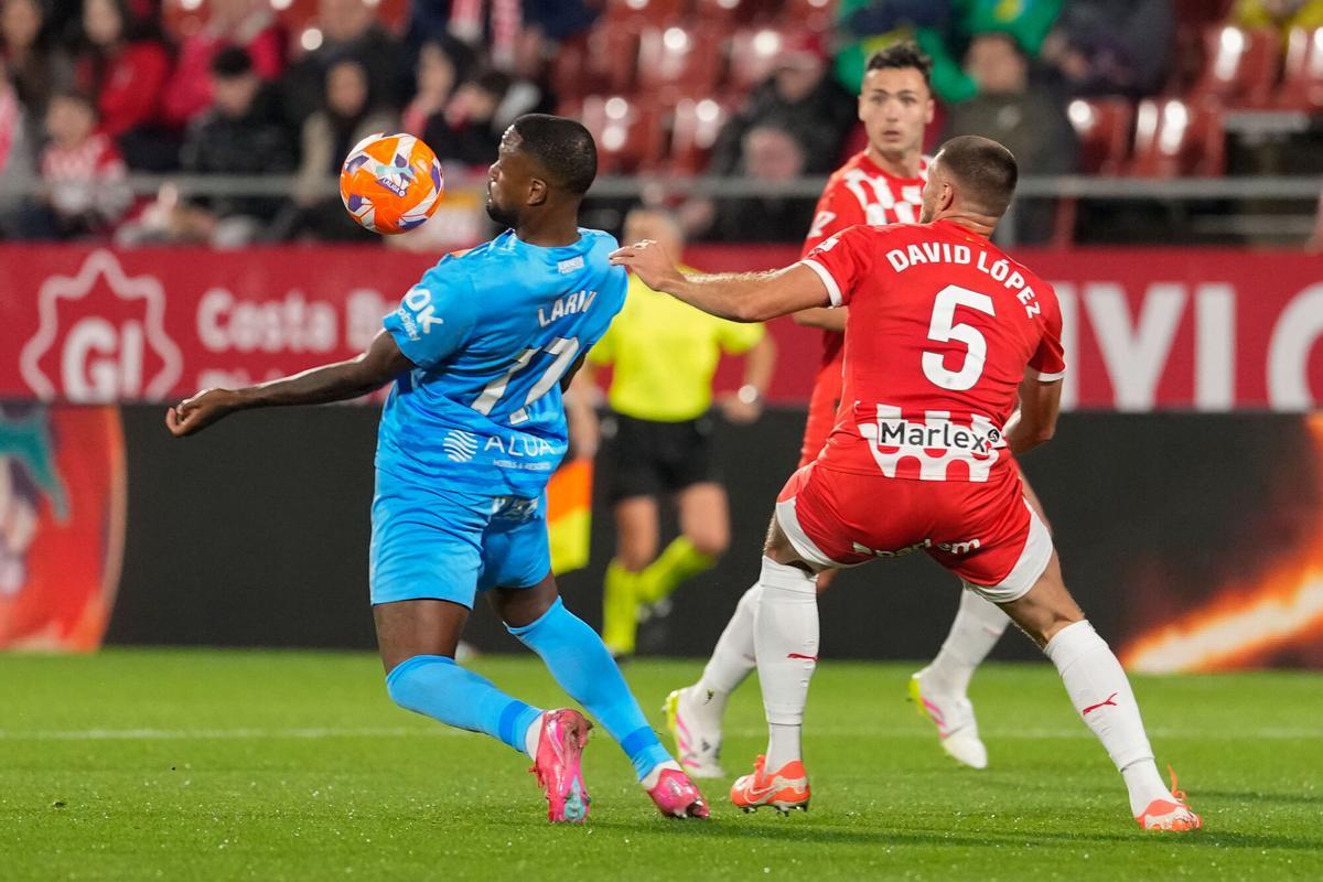 GIRONA, 05/05/2025.- El delantero del Mallorca Cyle Larin (i) protege un balón ante David López, del Girona, durante el partido de LaLiga de fútbol que Girona FC y Real Mallorca disputan este lunes en el estadio de Montilivi. EFE/David Borrat