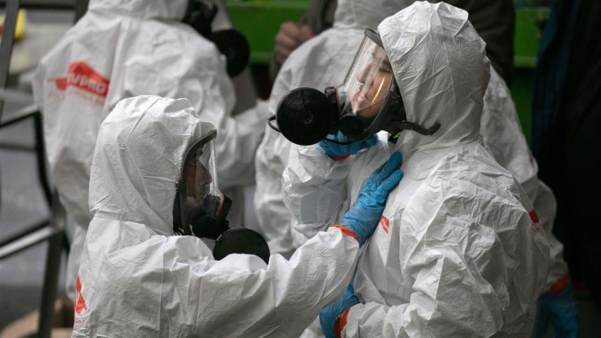 Una brigada de limpieza se protege antes de entrar en un centro de Kirkland, Washington, donde han habido víctimas de coronavirus.