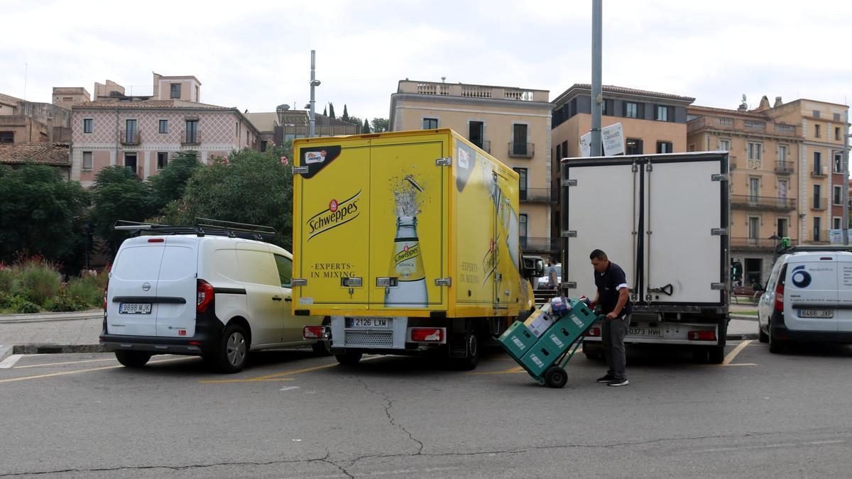 Un transportista descarregant begudes a la zona de càrrega i descàrrega de la plaça Catalunya de Girona