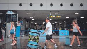 Turistas arrastran sus maletas y carros por las instalaciones del aeropuerto Tenerife Sur.